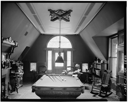Black and white photo of a recreation room with a pool table
