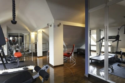 Photo of a gym with low ceilings, a wooden floor, and gym equipment