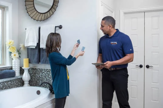 Five Star Painting estimator discussing paint colors with customer in bathroom