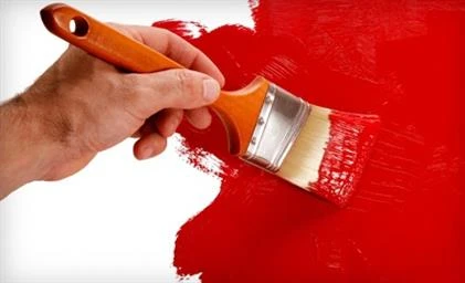 Painting white wall red with paintbrush