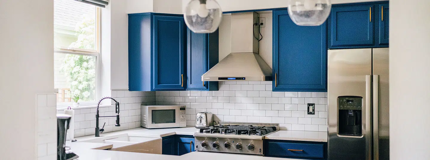 Kitchen cabinets refreshed in a bold blue finish by Five Star Painting as part of cabinet painting services