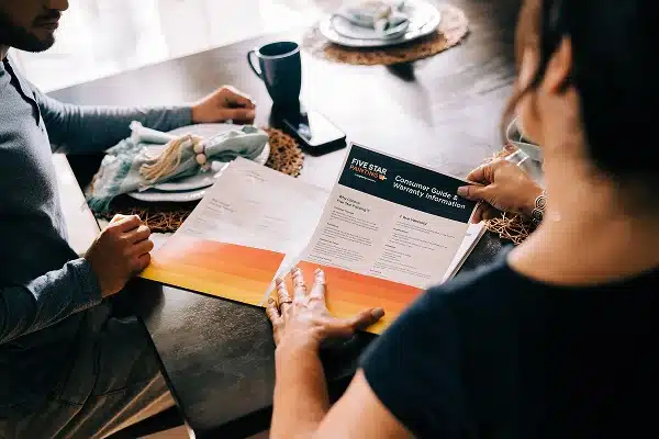 Homeowners reviewing a Five Star Painting brochure on professional painting services