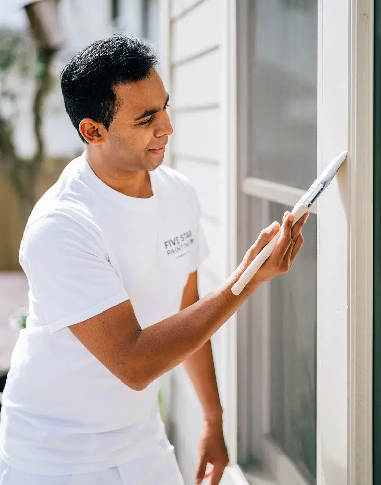 Five Star Painting professional painting exterior window trim during outdoor painting services