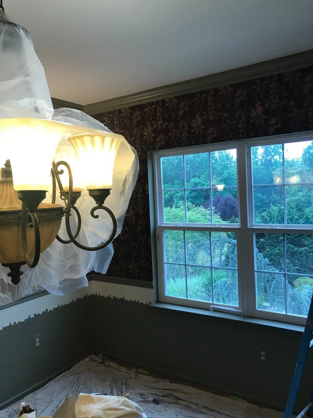 Wallpapered dining room where removal of wallpaper has begun