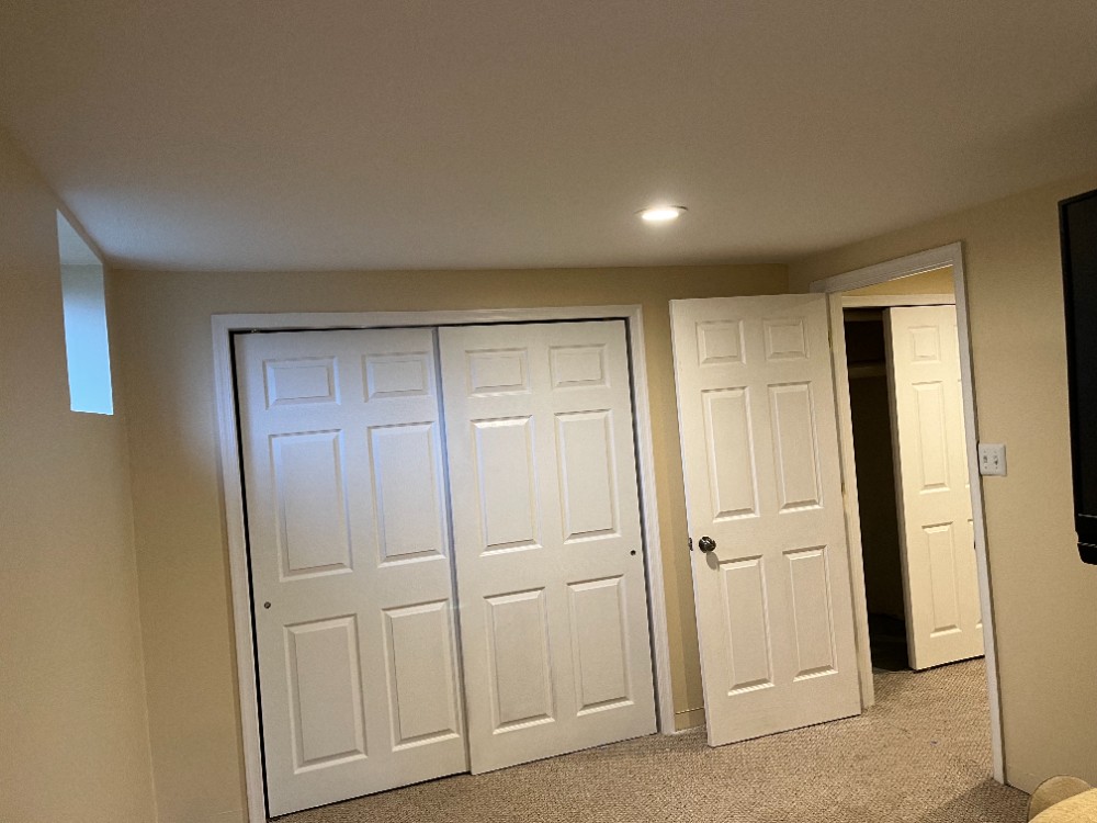 Beige basement walls white closets and doors