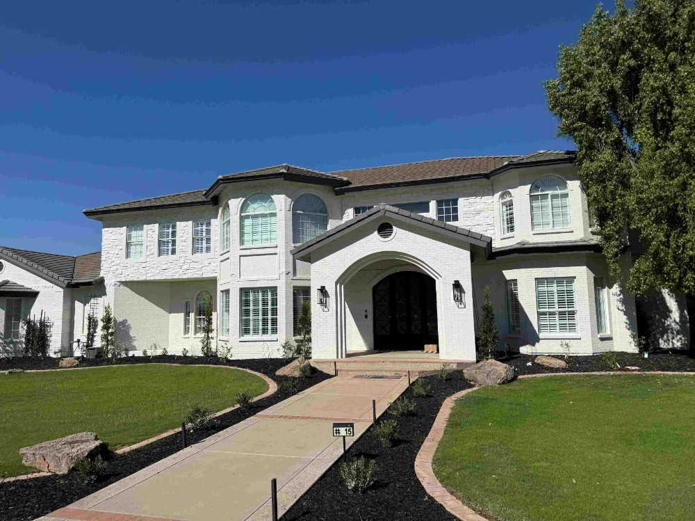 Exterior of a large brick and stucco home painted white