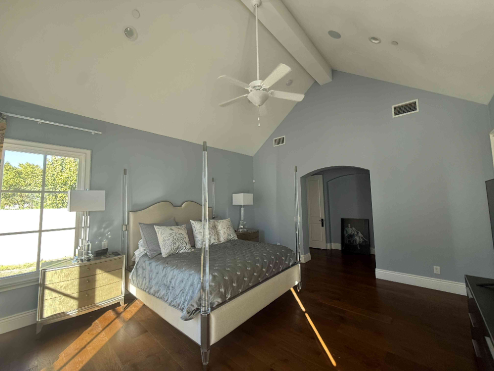 bedroom with post bed and high ceilings with painted walls