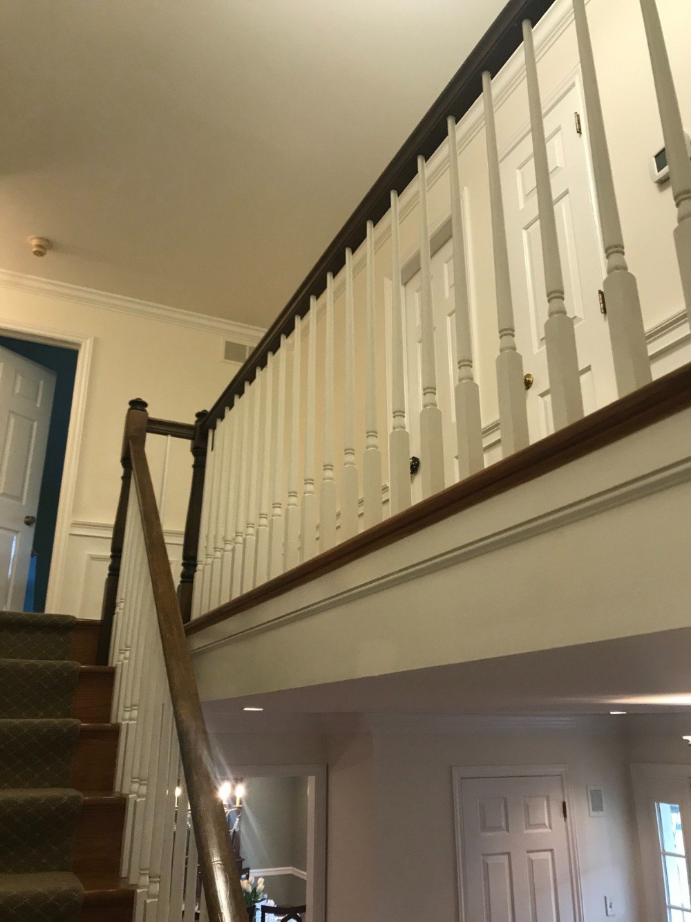 cream colored walls wooded banisters wood floors
