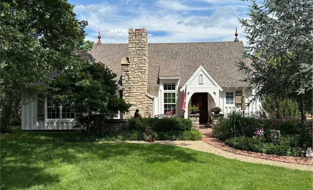Residential white siding exterior repaint with overhang, wood windows, door trim, and shutters