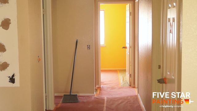 beige hallway leading to a yellow room