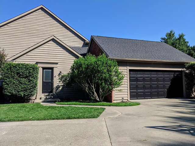 beige house black garage and front door