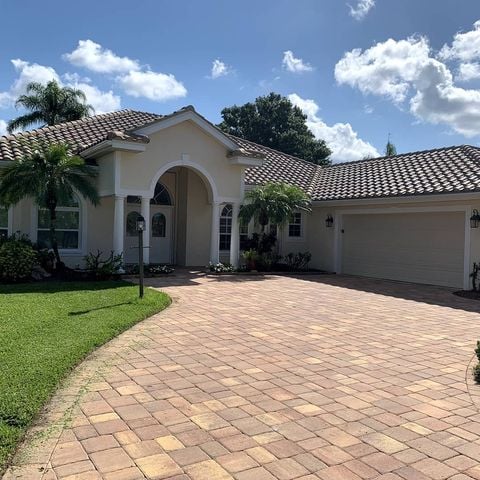 tan house with white accents and tile roofing