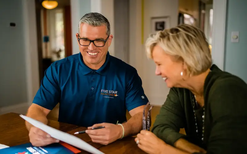 A Five Star Painting technician discussing financing options.
