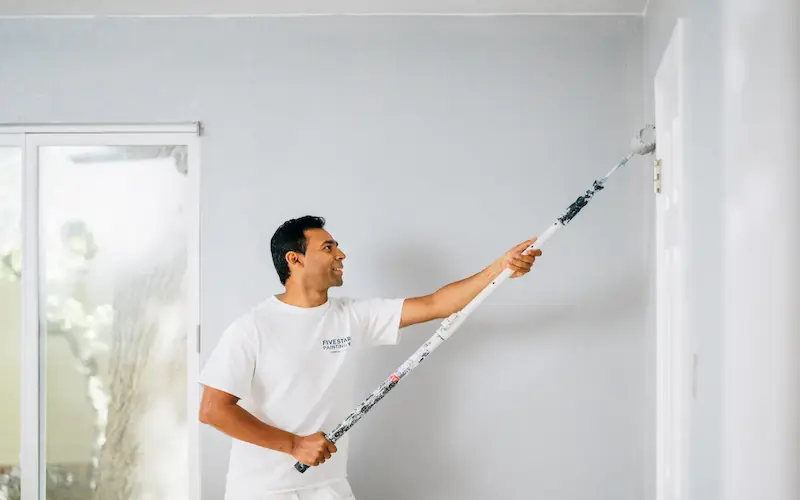 Five Star Painting technician painting home exterior.