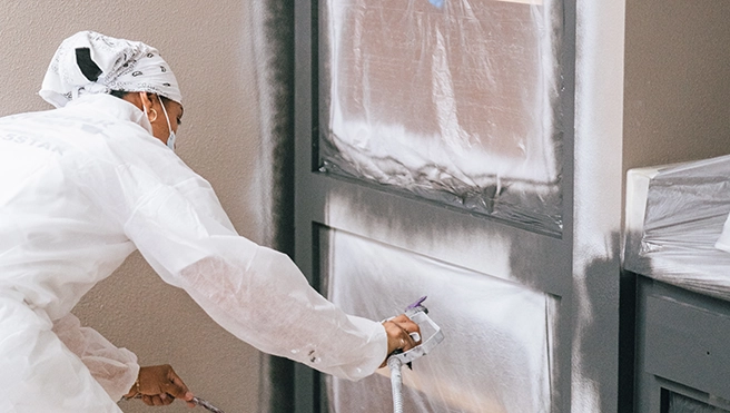 Protect Painters professional refacing a cabinet.