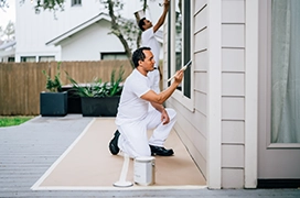 Protect Painters professional painting wood siding on the exterior of a home.