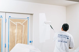 Protect Painters professional painting a wall.