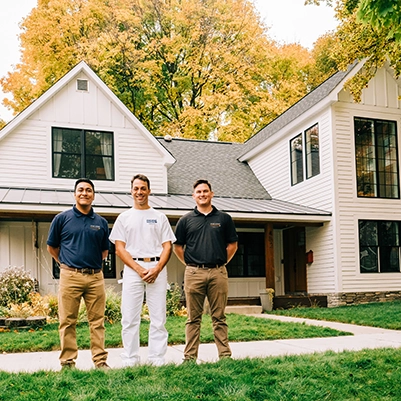Three Five Star Painting associates standing outside a house.