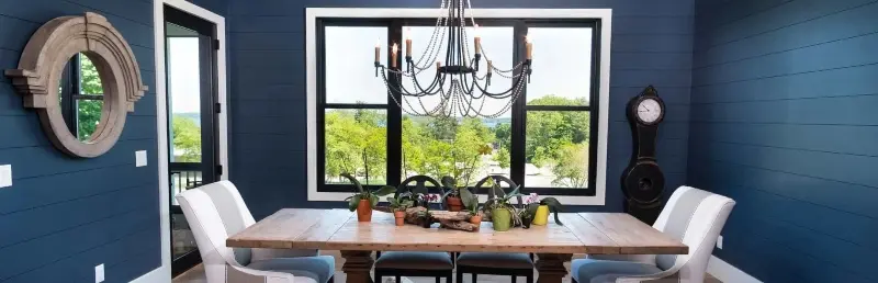 Dining room in original wall colours of dark blue overlooking a yard.