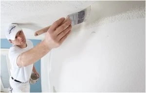 Five Star Painting employee using a paintbrush to paint the ceiling.