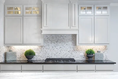 Beautiful white cabinets above a dark counter and cooktop