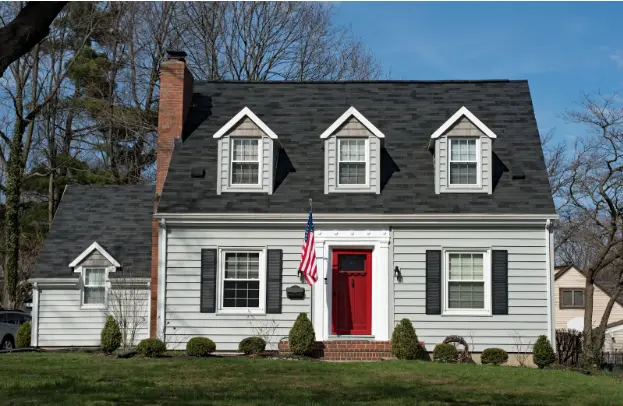 Freshly painted house with vinyl siding and red door. 