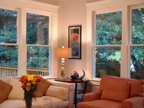 Couches in a living room in front of four windows