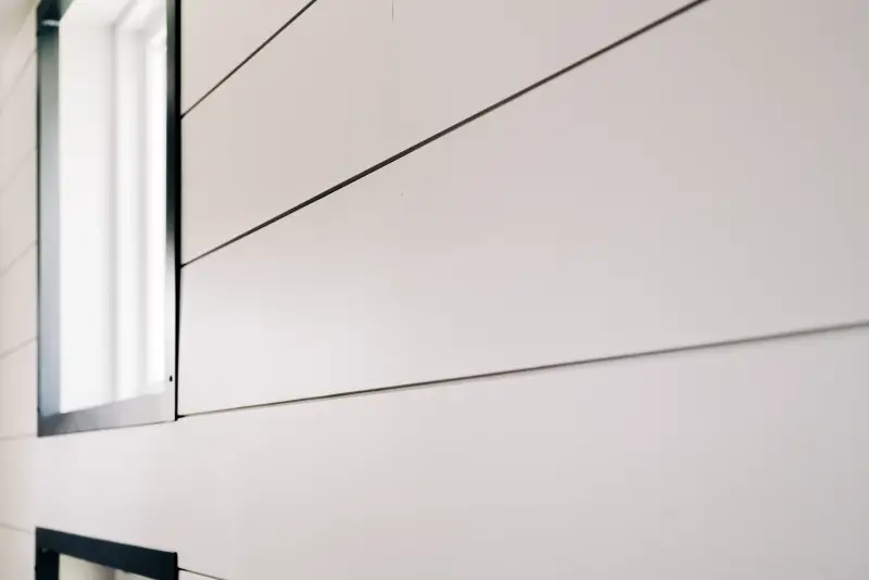 Close-up angled shot of white painted interior shiplap siding and black window trim.