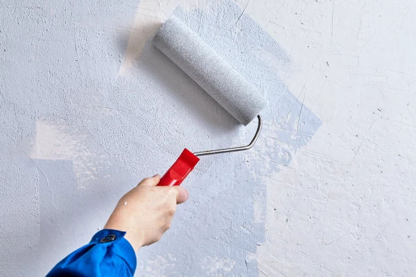 A paint roller painting a wall.