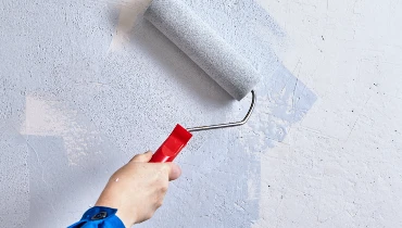 A paint roller painting a wall.