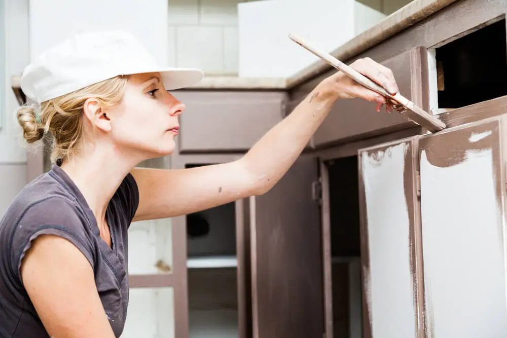 Woman painting kitchen cabinets