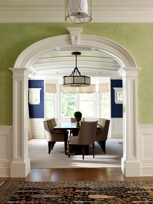 Dining room framed by wall with green paint and white crown molding
