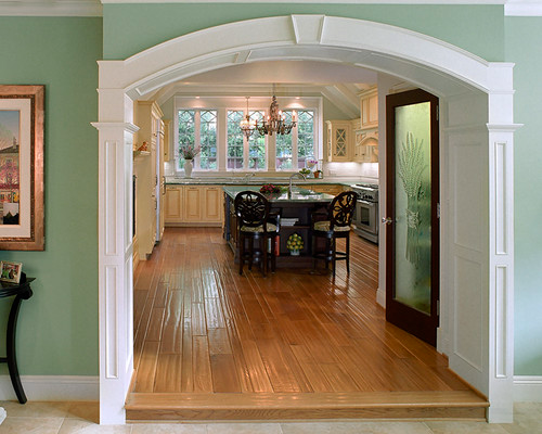 Dining room with wooden floors viewed through an archway