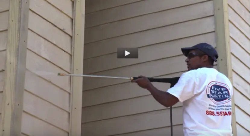 Photo of a Five Star Painting employee painting the outside of a house