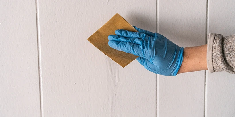 Person fixing a painting mistake on a wall