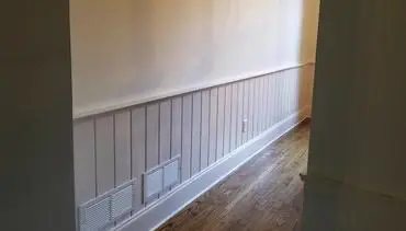 Residential hallway with cream paint and wood paneling