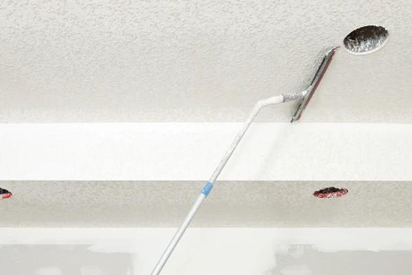 Photo of someone scraping ceiling popcorn off the ceiling