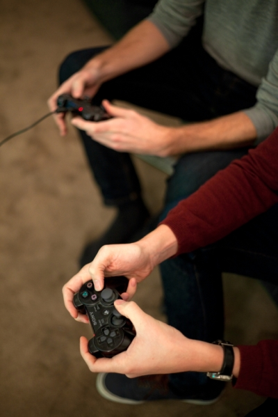 Closeup of Two Sets of Hands Holding Video Game Controllers  