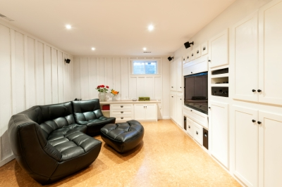 Large Black Sofa in an Open White Basement