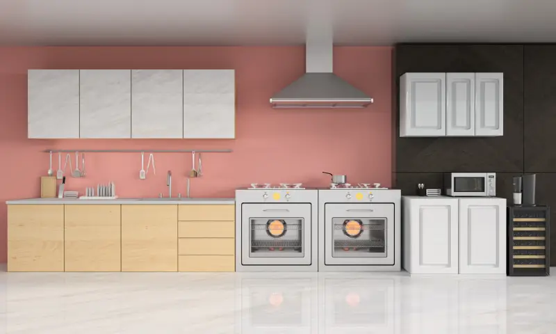 a modern kitchen with a pink wall and a black wall paired with white, marble, and wood cabinets and steel appliances