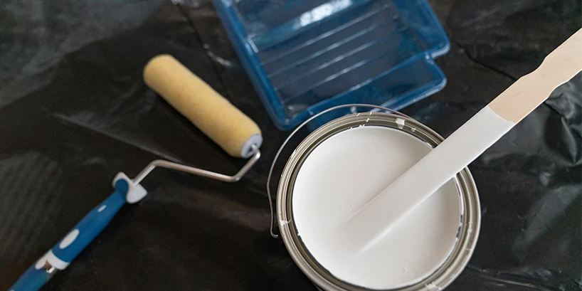 Painting materials and an open can of white paint