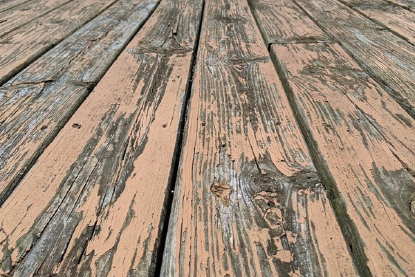 Tan paint peeling on a wood deck