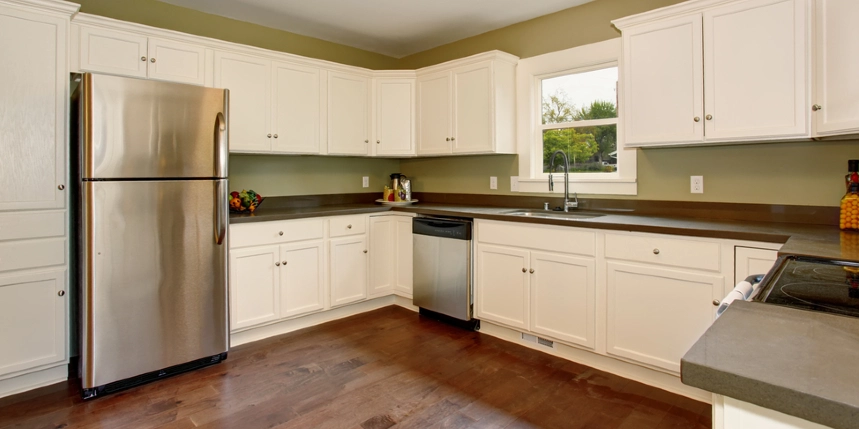 Photo of a large kitchen with white cabinets and a dark wooden floor