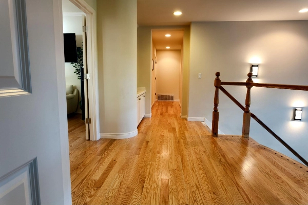 Upstairs hallway with oak wood floors and matching wall tones.