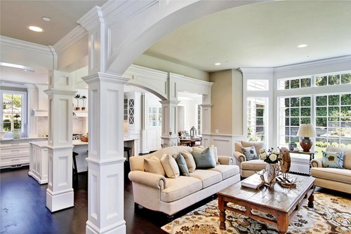 House with white walls, a dining room, a bar, and a wooden front door