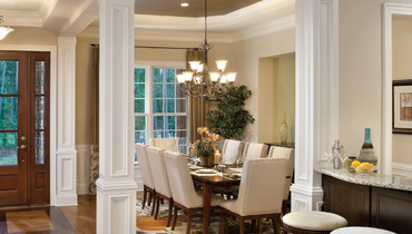 House with white walls, a dining room, a bar, and a wooden front door