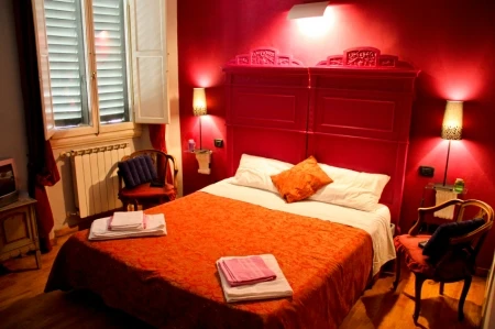 Master Bedroom with Red Headboard and Red Painted Accent Wall 