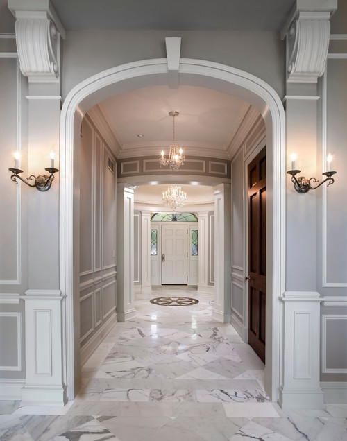 Hallway with marble floors leading to a front door