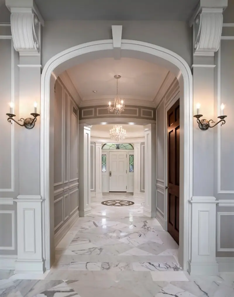 Hallway with marble floors leading to a front door