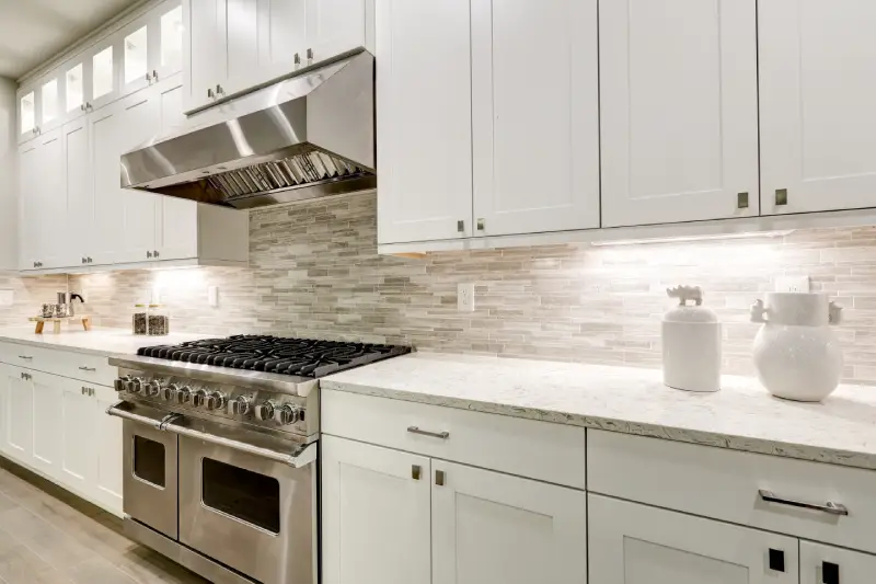 kitchen interior with white cabinets paired with a steel stove